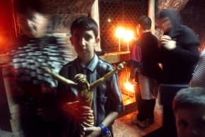 An Orthodox Christian boy holds a crucifix as he attends a service in the Church of the Holy Sepulcher in Jerusalem.