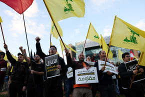 Protesters hold placards and Hezbollah flags during a demonstration condemning recent Israeli military actions in Lebanon, in Beirut, Lebanon February 4, 2026.
