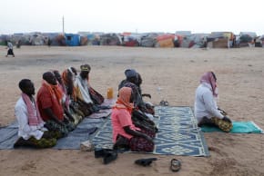 Internally displaced Somali men pray before Iftar outside their makeshift shelter after fleeing drought in the Lower Shabelle region to the camp in Mogadishu, Somalia, February 20, 2026.
