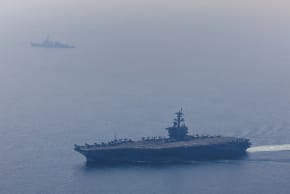 In this handout photo obtained from the US Defence Department, Nimitz-class aircraft carrier USS Abraham Lincoln (CVN 72) and Arleigh Burke-class guided-missile destroyer USS Frank E. Petersen Jr. (DDG 121) sail in the Arabian Sea, Feb. 6, 2026.