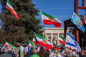 Demonstrators hold the "Lion and Sun" pre-Iranian Revolution national flags during a protest against Iran's government in front of the United Nations Office in Geneva, Switzerland, February 26, 2026