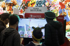 Gamers play the video game 'Super Smash Bros Ultimate' developed by Sora Ltd. and Bandai Namco and published by Nintendo on a Nintendo Switch console during the 'Paris Games Week' on October 27, 2018 in Paris, France.