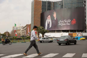 People walk near a billboard of Iran's late Supreme Leader Ayatollah Ali Khamenei on a street, after he was killed in Israeli and US strikes on Saturday, in Tehran, Iran, March 2, 2026