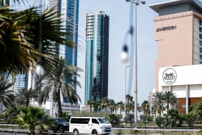 Vehicles drive past a building that was damaged by an Iranian drone attack, after Israel and the US launched strikes on Iran, in Seef, Manama, Bahrain, March 1, 2026