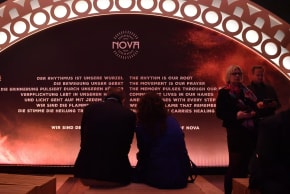 Visitors sit at the opening of the "Nova Music Festival Exhibition" in the former Tempelhof Airport in Berlin, Oct. 5, 2025