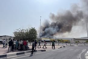 People gather as smoke rises at the Industrial Area after reported Iranian missile attacks, following United States and Israel strikes on Iran, in Doha, Qatar, March 1, 2026