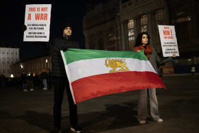 Anti-Iranian regime protesters hold Iranian flag before the 1979 revolution with the Lion and Sun emblems, during a gathering in support of the US and Israel attack of Iran and the killing of the Supreme leader Ayatollah Ali Khamenei in Turin on March 3, 2026. 