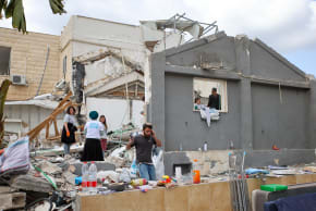 ISRAELIS VOLUNTEER at the site where a missile fired from Iran hit and caused major damage in Beit Shemesh, outside of Jerusalem, March 4, 2026.