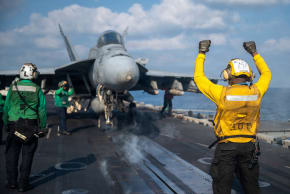 A US Navy sailor signals an F/A-18E Super Hornet on the flight deck of the Nimitz-class aircraft carrier USS Abraham Lincoln in support of the Operation Epic Fury attack on Iran at an undisclosed location March 4, 2026. 