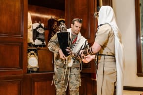 Jewish service members hold a torah scroll while wearing tefillin at the Aleph Institute's Military Symposium in February. 2026