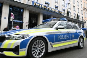 A police car passes the main entrance of the venue of the 62nd Munich Security Conference (MSC) the hotel "Bayrischer Hof" in Munich, southern Germany on February 12, 2026.