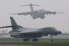 A United States Air Force (USAF) Boeing C-17A Globemaster comes in to land behind a USAF B-1B bomber parked beside the runway at RAF Fairford airbase, in Fairford, Britain, March 8, 2026.
