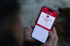 A man shows a missile alert notification on his mobile phone as residents take cover indoors following missile fire from Iran toward Israel, in Mishmar David, March 10. 2026.