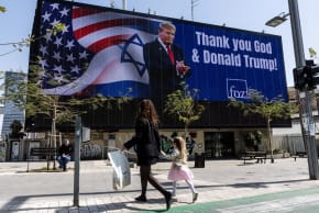 People walk by a billboard commissioned by an evangelical group, which displays a picture of U.S. President Donald Trump with the words "Thank you God & Donald Trump", amid the U.S.-Israel conflict with Iran, in Tel Aviv, Israel, March 12, 2026.