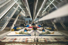 LIFE BETWEEN sirens. A woman rests on a mattress inside a Tel Aviv railway station serving as a bomb shelter on Tuesday. Two weeks into the war with Iran, Israelis continue to rush repeatedly to shelters as Iranian missile attacks disrupt daily life across the country. 