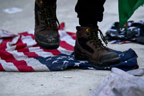 A protester steps on a US flag, at the end of a rally marking Al-Quds Day and opposing the war on Iran and Lebanon, at the U.S. Consulate in Toronto, Ontario, Canada, March 14, 2026.