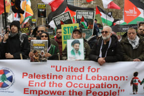 PROTESTERS FORM up behind a banner during a pro-Palestinian demonstration in London, on March 15, 2026.