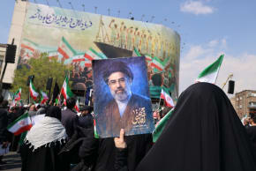 Iranians wave flags, hold posters of Supreme Leader Mojtaba Khamenei, at a funeral for Iranian officials, including Ali Larijani, in Tehran, March 18, 2026; illustrative.