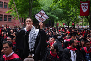 A student stands and whistles while holding his cap with the words 'End The Occupation' during the 373rd Commencement Exercises at Harvard University in Cambridge, Massachusetts, US, May 23, 2024.