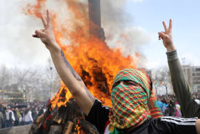 People gesture near a bonfire during Nowruz celebrations in Diyarbakir, southeastern Turkey, March 21, 2026.