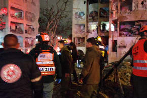First responders operate at a site of a direct missile strike on an Arad building, southern Israel, March 21, 2026