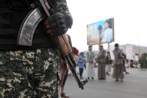 A Yemeni security soldier guards next to a large screen broadcasting the leader of Houthi movement, Abdul-Malik al-Houthi, alongside messages supporting Palestinians and the cause of Jerusalem, during a rally by Houthi supporters on International Quds Day on March 13, 2026 in Sana'a, Yemen.