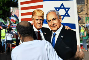 A member of the Iranian community in Australia holds a placard in support of US President Donald Trump and Israeli Prime Minister Benjamin Netanyahu during a rally following US and Israeli attacks on Iran sparking the Middle East war, in Sydney on March 14, 2026.