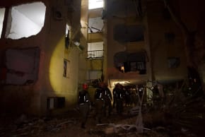 RESCUE FORCES arrive at the scene where an Iranian missile struck residential buildings in the southern Israeli city of Arad. 