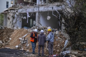 Workers operate at the scene where a missile fired from Iran caused damage in Tel Aviv, March 25, 2026