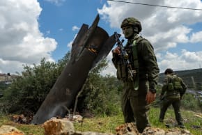  Israeli soldiers stand near an Iranian missile embedded in the ground on March 24, 2026 in the Palestinian village of Hares, West Bank. Iranian missiles have routinely flown over, and sometimes landed in, the West Bank during Israel's war with Iran.