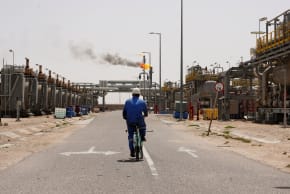 A worker rides a bicycle at the Zubair oil field in Basra, Iraq, April 6, 2026.