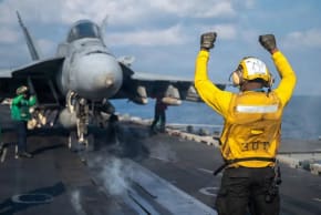 Un marinero de la Armada de los Estados Unidos da señales a un F/A-18E Super Hornet en la cubierta de vuelo del portaaviones de la clase Nimitz USS Abraham Lincoln, en el marco de la Operación Epic Fury contra Irán, en un lugar no revelado, el 4 de marzo de 2026. 