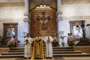 A priest leads the the Easter Vigil at the Our Lady of Perpetual Help Chaldean Catholic Church in Arbil, the capital of the autonomous Kurdish region of northern Iraq, on April 4, 2026.