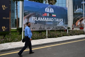 A police officer walks past a billboard for the USIran peace talks in Islamabad on April 11, 2026.