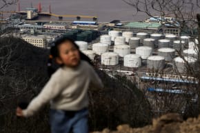  A child walks along a hiking trail with oil storage tanks and facilities of CNOOC Ningbo Daxie Petrochemical Co., Ltd. in the background in Ningbo, Zhejiang, China, March 21, 2026. 