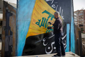A man paints the Hezbollah flag on a board in Tyre, south Lebanon, April 14, 2026