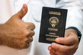  A voter holds his proof of Kuwaiti citizenship upon arriving at a polling station during parliamentary elections in Kuwait City on June 6, 2023.