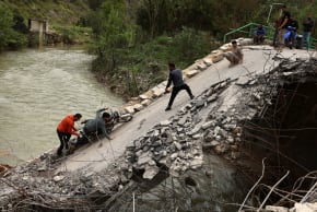 People help a man on a motorcycle to cross a bridge linking southern Lebanon to the rest of the country, which was hit in an earlier Israeli strike, amid a 10-day ceasefire between Lebanon and Israel, in Zrarieh, Lebanon, April 19, 2026. 