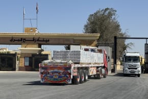 A truck loaded with humanitarian aid waits to cross from the Egyptian side of Rafah en rounte to the Kerem Shalom crossing into the Gaza Strip on October 20, 2025.
