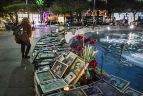People next to photos of victims of terror attacks and fallen Israeli soldiers at Dizengoff Square in Tel Aviv on the eve of Israel’s Memorial Day, April 20, 2026.