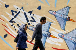 Unos iraníes pasan junto a un mural contra Estados Unidos e Israel en Teherán, el 21 de abril de 2026, en medio de un alto el fuego en la región.