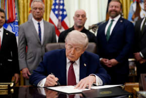  U.S. President Donald Trump signs an executive order encouraging more research into ibogaine, next to U.S. Health and Human Services (HHS) Secretary Robert F. Kennedy Jr., Joe Rogan, and Americans for Ibogaine CEO W. Bryan Hubbard, in the Oval Office of the White House in Washington, D.C., April 18