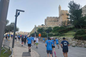 Runners make their way uphill toward Jaffa Gate, passing beneath the Tower of David’s iconic walls.