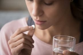 A woman taking a pill