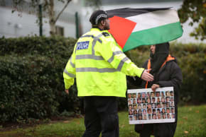  A POLICE officer stops a protester impeding staff turning onto the main road on October 16, 2023 in Leicester.
