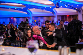 White House Deputy Chief of Staff for Policy Stephen Miller and his wife Katie Miller (C) are taken out of the ballroom by security agents during a shooting incident at the annual White House Correspondents Association Dinner at the Washington Hilton on April 25, 2026 in Washington, DC.