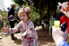 Shayna, a Jewish Ukrainian refugee from the Alumim children's home in Zhytomyr, Ukraine, catches bubbles as part of celebrations of the Jewish holiday of Purim after arriving to Israel following Russia's invasion of Ukraine.