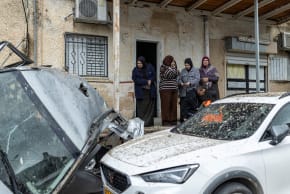Arab Israelis survey the damage following a missile strike in the Arab Israeli city of Kafr Kassem on March 26. 