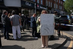 A demonstrator holds a sign near a police cordon, after a man was arrested following a stabbing incident in the Golders Green area, which is home to a large Jewish population, in London, Britain, April 29, 2026. (photo credit: REUTERS/HANNAH MCKAY)