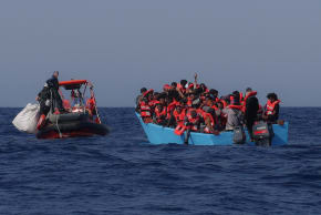 Migrants aboard an overcrowded boat react as they are approached by the crew of the migrant search and rescue ship Sea-Watch 5, operated by the German NGO Sea-Watch, during a rescue operation in the Search and Rescue (SAR) zone in the central Mediterranean, off Libya, August 11, 2025.